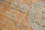 Distressed Oushak carpet pile showing mostly even wear, pale tangerine, faded blue, and mint.