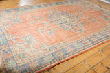 Distressed Oushak carpet texture with mostly even wear showing on pale red field.