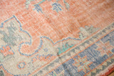 Distressed pile texture on vintage Oushak rug with pale red, ivory, sky blue, mint green.