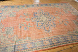 Hand knotted vintage Oushak rug, distressed coral field, blue medallion, Rococo palmette motifs.