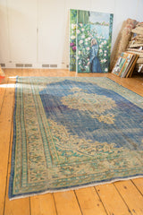 Evenly worn Oushak carpet texture, with faded blues and antique ivory patterns.
