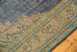 Distressed blue Oushak rug shows patterned beige border with mint green motifs.