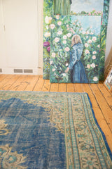 Distressed blue field and intricate antique ivory, beige, and mint green border.