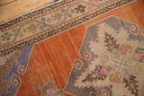 Medallion corner with scrolling outlines and pink accents against a warm tangerine orange field.