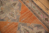 Visible wear to foundation on a distressed Oushak rug with tangerine, gray, and pink motifs.