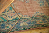 Distressed Oushak rug border detail featuring blush, faded blue, and aqua tones.