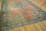 Visible wear and faded royal blue border with aqua green tones on vintage distressed Oushak rug.