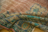 Distressed Oushak rug texture with blush, aqua green, and faded blue hues, mostly worn to knot heads.