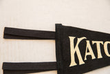 Close-up of the black pennant's stitched edge and wool felt tie straps.