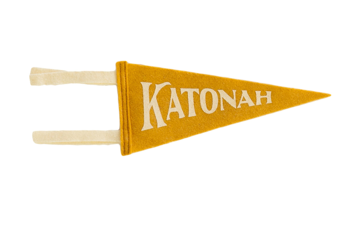 Old gold Katonah NY mini felt pennant with off-white lettering and hanging ties.