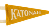 Detail view of the Katonah pennant's golden yellow felt and cream serif-style letters.