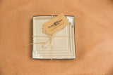 Linen napkin corner featuring aqua blanket stitch, playful fringe, and Freckles and Fabric tag.