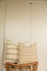 Pair of wool fabric pillows showcasing distinct wide grey and fine blue-grey stripes.