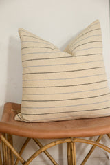 Delicate black and pale blue horizontal stripes on a beige remnant silk fabric pillow.