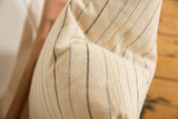 Textural detail of the cream remnant silk throw pillow fabric with delicate blue and black stripes.