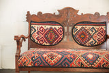 Intricately carved vintage bench backrest with a vibrant geometric Kilim upholstered panel.