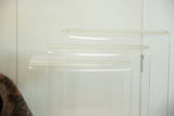 Curved tops and clear Lucite surfaces of vintage nesting tables with subtle wear.