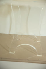 Thick Lucite end table's curved legs showing clear, substantial form.