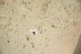 Detailed view of the ceramic lamp's pitted faux travertine finish.