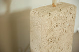 Top corner detail of the faux travertine lamp showing its porous, stone-like ceramic texture.