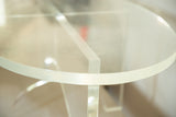 Thick clear Lucite oval coffee table top with intersecting base detail.