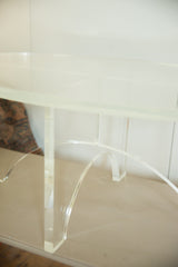 Thick clear Lucite oval table top with unique crisscross base detail.