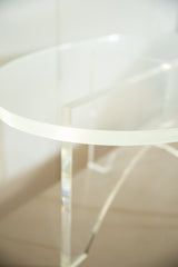 Thick clear edge of the vintage Lucite oval coffee table's top and crisscross base.