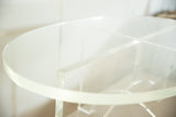 Thick clear Lucite oval tabletop with intersecting crisscross base of vintage coffee table.