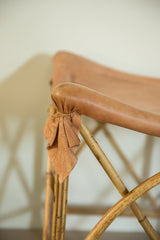 Gathered tan deerskin texture and natural bamboo frame detail on vintage foot stool.