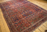 Persian Fereghan carpet's madder red field featuring cobalt blue arabesques and intricate floral motifs.