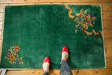 Art Deco emerald green rug with intricate floral bouquet and expressive ribbon.