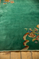Emerald green Art Deco rug corner with intricate floral bouquet and expressive ribbon motif.