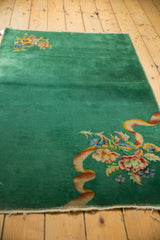 Nichols Art Deco rug detail: intricate floral bouquet with expressive ribbon, emerald green field.