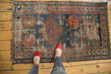 Upper-left corner of Antique Caucasian rug, revealing storied wear, frayed fringe, and geometric patterns.