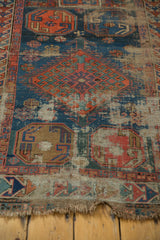 Colorful geometric border and visibly tattered fringe on the antique Caucasian rug.