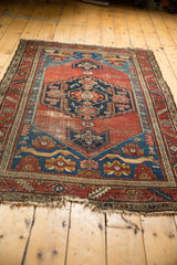 Antique Persian Malayer rug detail: sapphire blue corner spandrel, madder red field, and floral patterns.