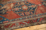 Antique Malayer rug with sapphire blue spandrel, stylized floral and animal motifs, worn red field.