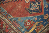 Antique Malayer rug: sapphire blue corner spandrel, madder red field wear and creature motifs.