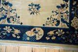 Decorative border detail of the Peking rug with indigo blue birds, flowers, and fringe.
