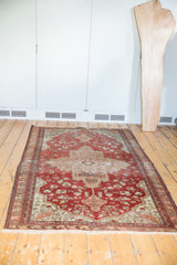 Antique Farahan Sarouk rug corner, featuring rich terra cotta floral motifs and ivory fringe.