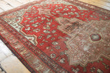 Subtle geometric floral motifs and visible foundation in the worn field of an antique Farahan Sarouk rug.