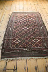 Recessed lattice pattern and natural fringe on an antique Belouch rug.
