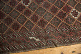Antique Belouch rug's etched charcoal, wine red lattice and patterned plain weave end.
