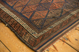 Antique Belouch rug corner showcasing intricate pawn design border and original goat hair selvage.