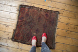 Antique Belouch rug's geometric starburst gul motifs, showing wear and tattered ends.