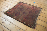 Antique Belouch rug featuring allover starburst gul motifs, latched rams horn detailing, and visible wear.