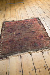 Antique Belouch rug's starburst gul pattern in chocolate, blush, navy, and its distinct worn fringe.