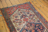 Malayer rug fragment: deep navy medallion corner, worn beige field with Herati motifs, and evident pile loss.
