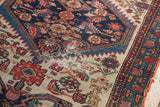Threadbare regions and visible foundation on a hand-knotted antique Malayer rug.