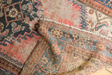 Vintage Kurdish Malayer rug showing threadbare pile, exposed foundation, navy, and blush red patterns.
